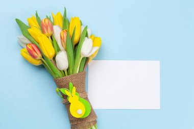 Paskalya tebrik kartı, paskalya tavşanı dekoru ve mavi arka planda lale çiçekleri. Üst görünüm düzlüğü kopyalama alanı ile yatıyordu