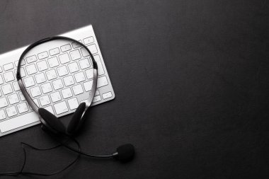 Kulaklık ve klavyeli ofis masası. Uzaktan ofis ve ev konseptinden çalışma. Üst görünüm düzlüğü kopyalama alanı ile yatıyordu