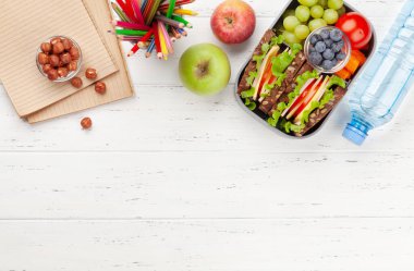 Sandviç, taze sebze, su şişesi, fındık ve meyveli sağlıklı okul beslenme çantası. Üst görünüm düzlüğü kopyalama alanı ile yatıyordu