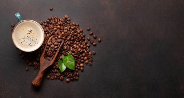 Kavrulmuş kahve çekirdeği ve bir fincan sıcak espresso kahvesi. Üst görünüm düzlüğü kopyalama alanı ile yatıyordu  