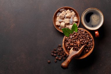 Kavrulmuş kahve çekirdekleri, esmer şeker ve bir fincan sıcak espresso kahvesi. Üst görünüm düzlüğü kopyalama alanı ile yatıyordu