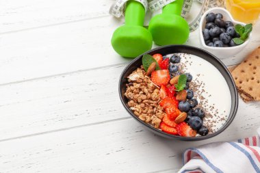 Sağlıklı kahvaltı, tahıl gevreği, yoğurt ve taze böğürtlen. Fitness protein yemeği. Dambıl ve mezura. Diyet konsepti. Kopyalama alanı ile