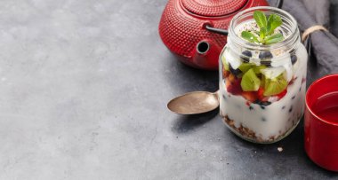 Sağlıklı kahvaltı, bir kavanoz granola, yoğurt ve taze böğürtlen. Fitness protein yemeği ve diyet konsepti. Kopyalama alanı ile
