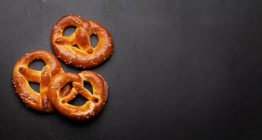 Taze pişmiş ev yapımı simit ve taş masada deniz tuzu. Klasik bira atıştırmalığı. Üst görünüm düzlüğü kopyalama alanı ile yatıyordu