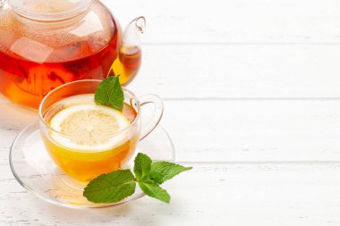 Nane ve limonlu bitki çayı. Çay fincanı ve çaydanlık ahşap masada. Kopyalama alanı ile