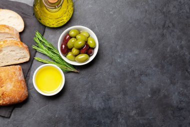 Olgun zeytin, zeytinyağı ve ciabatta ekmeği. Üst görünüm düzlüğü kopyalama alanı ile yatıyordu