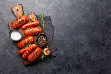 Ahşap tahtada baharatlı ızgara sosis. Üst görünüm düzlüğü kopyalama alanı ile yatıyordu