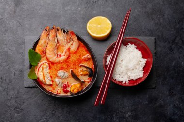 Geleneksel Tayland çorbası Tom Yum kung deniz ürünleri, hindistan cevizi sütü, biber ve pirinç kasesi. Üst görünüm düzlüğü