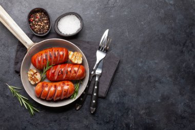 Kızartma tavasında ızgara sosis, ketçap ve hardal. Üst görünüm düzlüğü kopyalama alanı ile yatıyordu