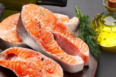 Taze çiğ somon yemeği. Kesme tahtasındaki baharatlı ve otlu balık bifteği.