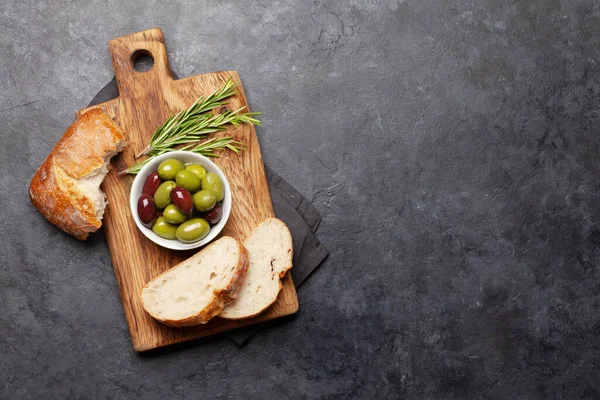 Olgun zeytin ve ciabatta ekmeği. Üst görünüm düzlüğü kopyalama alanı ile yatıyordu