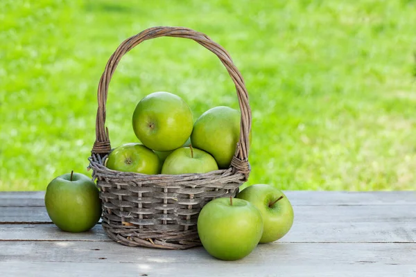 バスケットに新鮮な庭の緑のリンゴ テキストのコピースペースがある屋外のテーブルで — ストック写真