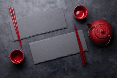Suşin ve makin için taş tabaklar ve çubuklar. Japon yemek menüsü arka planı. Üst görünüm düzlüğü kopyalama alanı ile yatıyordu