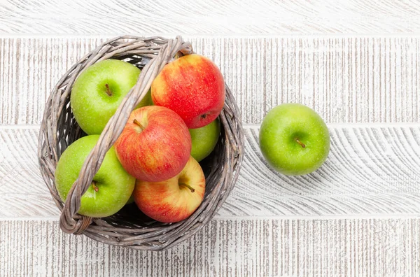 木の背景にバスケットに新鮮な熟したリンゴ 赤と緑のリンゴの果物 コピースペース付きのトップビューフラットレイ — ストック写真