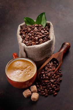 Roasted coffee beans, brown sugar and cup of hot espresso coffee