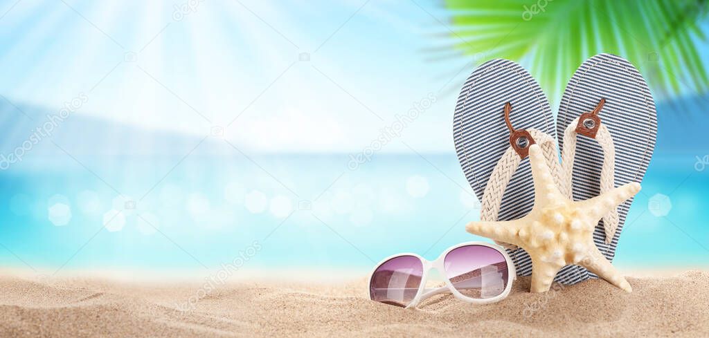 Flip flops on sunny sea beach with copy space. Summer sea vacation and travel concept