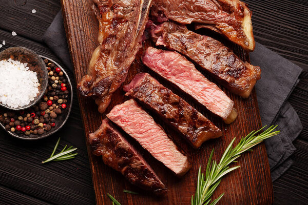 T-bone grilled beef steak with spices and herbs. Top view flat lay