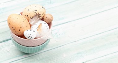 Tavuk ve bıldırcın yumurtaları ahşap masada kasede. Paskalya yumurtaları. Kopyalama alanı ile