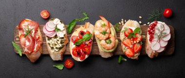 Geleneksel İspanyol tapas setiyle aperatifler. İtalyan antipasti brushetta atıştırmalıkları. Üst görünüm düzlüğü