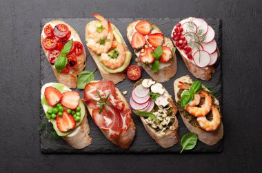 Geleneksel İspanyol tapas setiyle aperatifler. İtalyan antipasti brushetta atıştırmalıkları. Üst görünüm düzlüğü