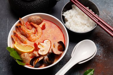 Geleneksel Tayland çorbası Tom Yum kung deniz ürünleri, hindistan cevizi sütü, biber ve pirinç kasesi.