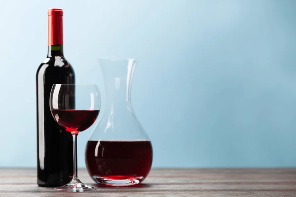 Weinflasche Mit Rotwein Weinglas Und Karaffe Auf Holztisch Vor Blauem — Stockfoto