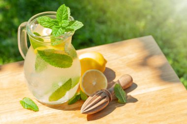 Limonlu ve naneli taze ev yapımı limonata. Güneşli bir günde açık bahçe masası