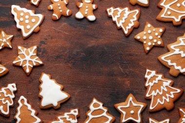 Tahta arka planda zencefilli kurabiyeli Noel kartı. Üst görünüm düzlüğü Xmas selamları için boşluk ile yatıyordu