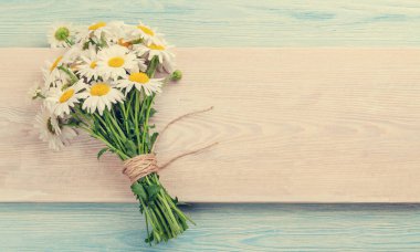 Mavi ahşap masada papatya çiçeği buketi. Üst görünüm düzlüğü kopyalama alanı ile yatıyordu