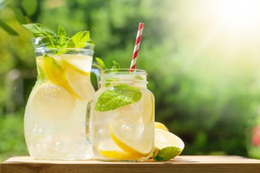 Limonlu ve naneli taze ev yapımı limonata. Güneşli bir günde açık hava bahçe masası. Kopyalama alanı ile