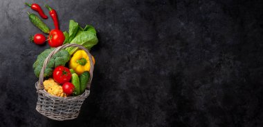 Mutfak masasında taze sebzeli sepet. Üst görünüm düzlüğü kopyalama alanı ile yatıyordu