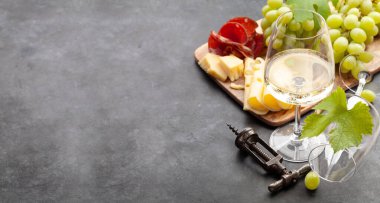 Beyaz şarap bardakları, üzüm ve peynir ve jambonlu aperatif. Kopyalama alanı ile