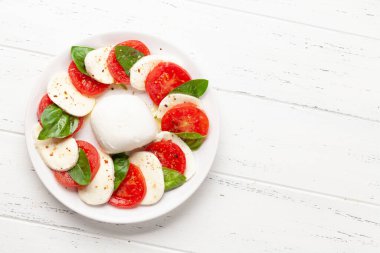 Mozzarella, fesleğen ve taze domatesli Caprese salatası. Üst görünüm düzlüğü kopyalama alanı ile yatıyordu
