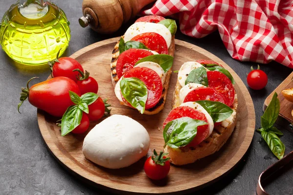 モッツァレラチーズ バジル 焼きトーストの上に新鮮な庭のトマトとケープレスサラダ — ストック写真