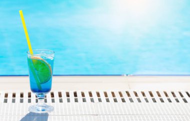 Yüzme havuzunun kenarında kokteyl bardağı var. Seyahat ve tatil. Kopyalama alanı ile