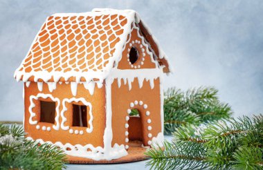 Noel tebrik kartı, zencefilli kurabiye evi, karlı köknar ağacı ve kopyalama alanı.