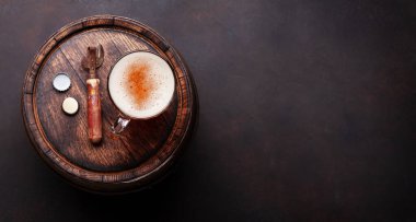 Bira bardağı ve şişe açacağı eski ahşap fıçının üzerinde. Üst görünüm düzlüğü kopyalama alanı ile yatıyordu
