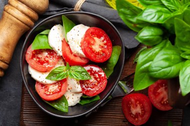 Taze domatesli Caprese salatası, fesleğen ve mozzarella peyniri. Üst görünüm düzlüğü