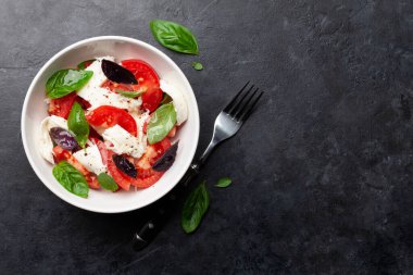Taze domatesli Caprese salatası, fesleğen ve mozzarella peyniri. Üst görünüm düzlüğü kopyalama alanı ile yatıyordu