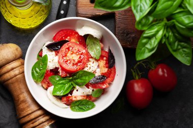 Taze domatesli Caprese salatası, fesleğen ve mozzarella peyniri. Üst görünüm düzlüğü