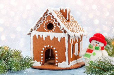 Zencefilli ekmek evi, kardan adam ve köknar ağacı olan Noel tebrik kartı.