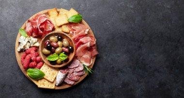 Prosciutto, salam, kraker, peynir ve zeytinli pansiyon. Üst görünüm düzlüğü kopyalama alanı ile yatıyordu