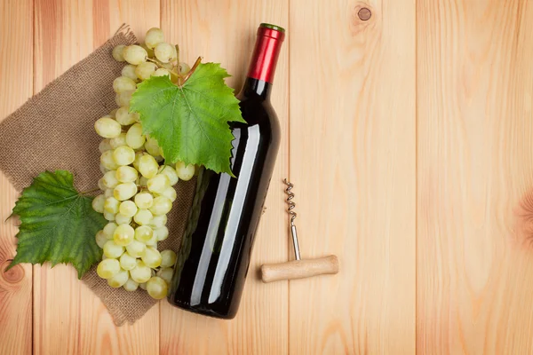 Garrafa de vinho tinto e uvas brancas — Fotografia de Stock
