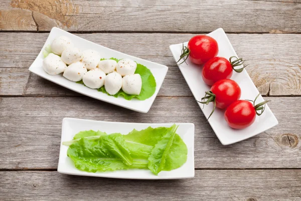 Tomates, mozzarella y hojas de ensalada verde —  Fotos de Stock