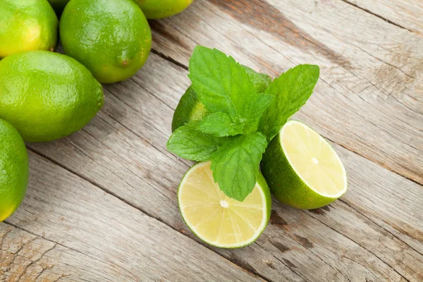 Frische reife Limetten mit Minze — Stockfoto