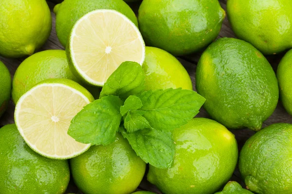 Frische reife Limetten mit Minze — Stockfoto