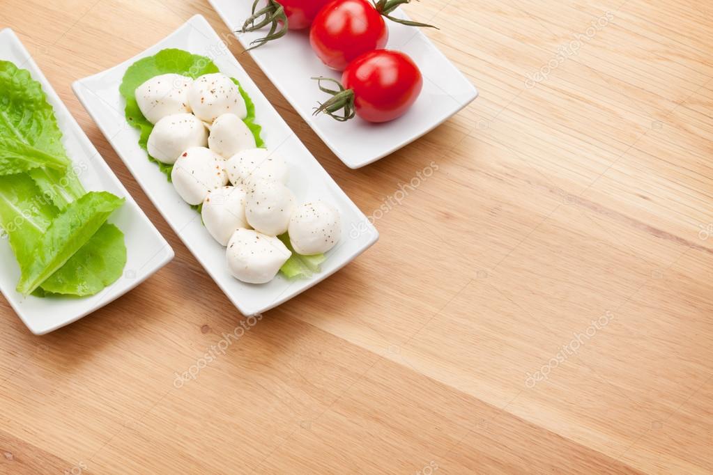 Tomatoes, mozzarella and green salad leaves