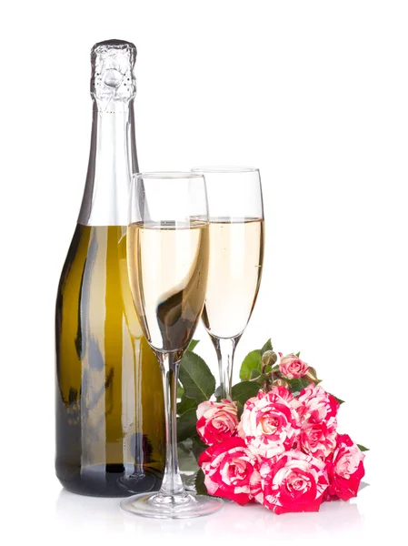 Láhev šampaňského, dvě sklenice a červené květy růže — Stock fotografie