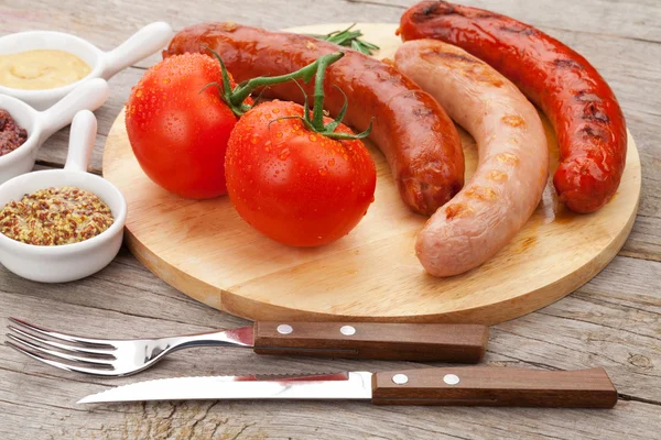 Grilled sausages with condiments — Stock Photo, Image