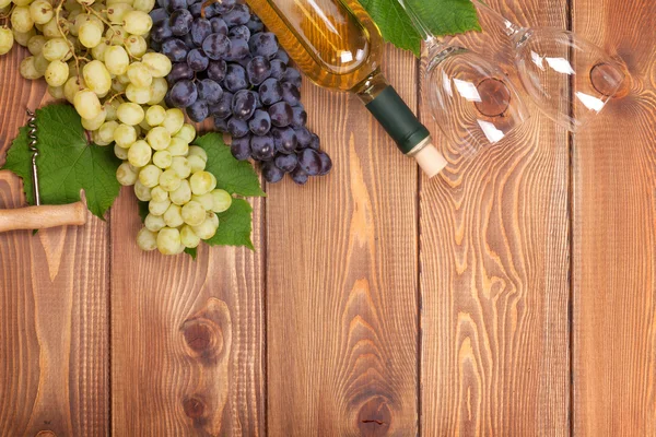 Garrafa de vinho branco e um monte de uvas — Fotografia de Stock